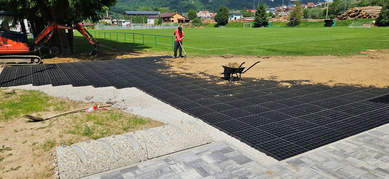 montáž plastových zatrávňovačov na spenenie povrchu pri futbalovom ihrisku