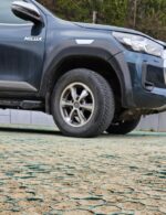 Zelená zatrávňovacia dlažba Multigravel pod kolesami SUV vozidla na spevnenom parkovisku