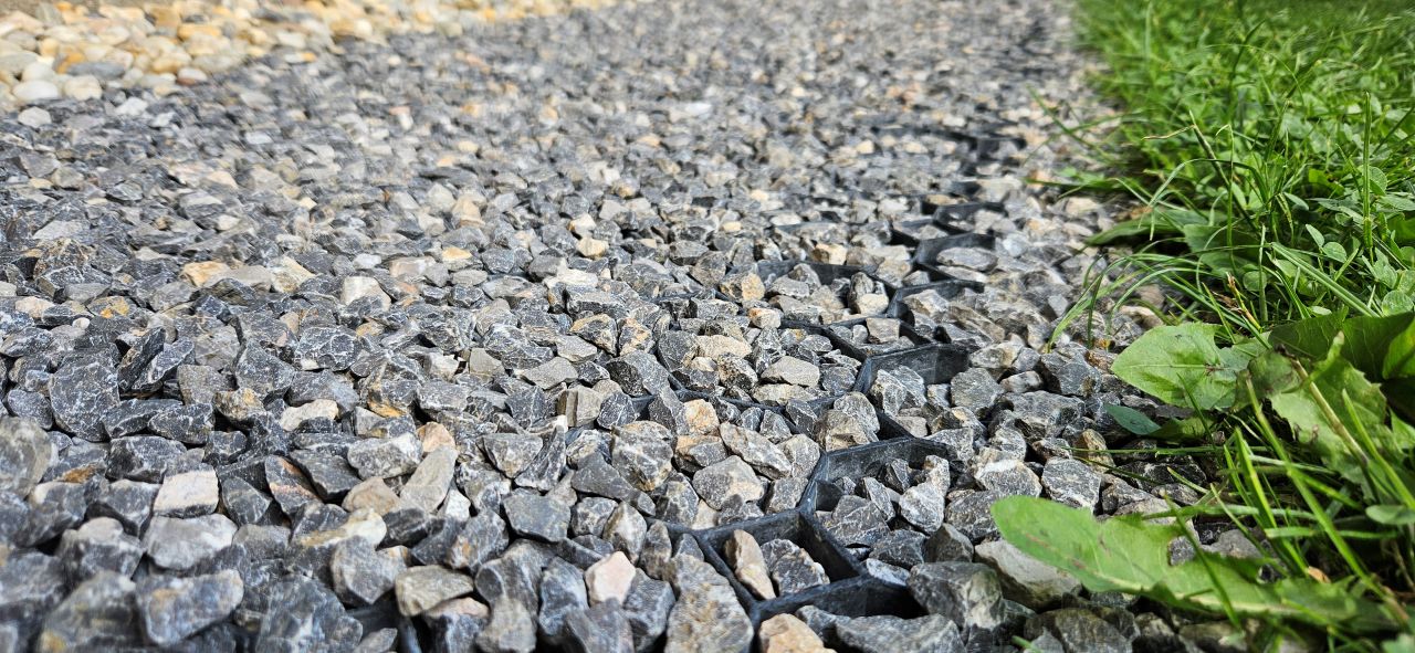 plastový zatrávňovač na zahradnej cestičke vyplnený štrkom