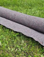 Geotextília GeoNetex M200 200 g/m² čiastočne rozvinutá na trávniku na oddelenie vrstiev